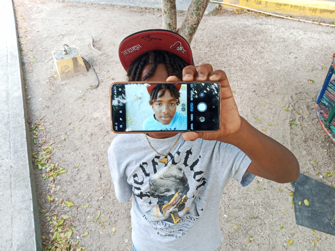 Jongen fotografeert zichzelf via zijn telefoon — foto gemaakt door een jongere tijdens de workshop